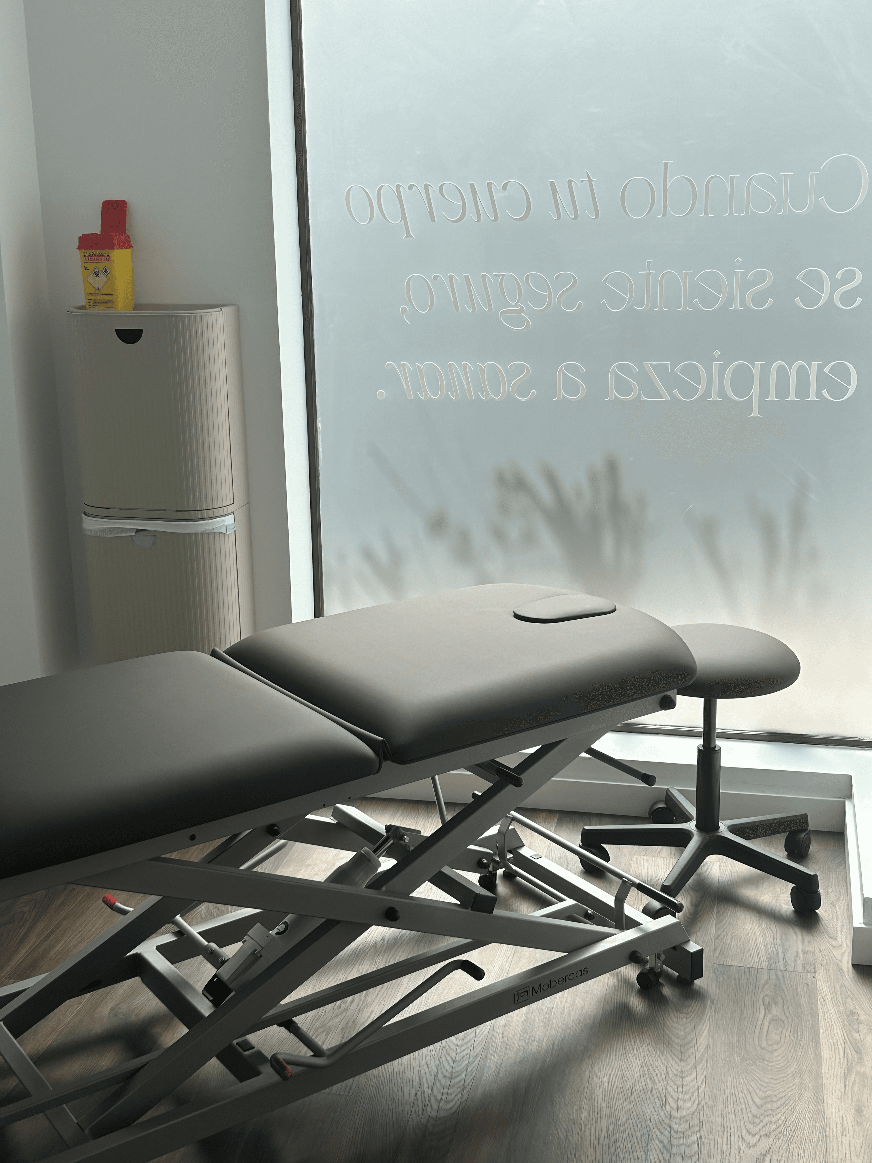 Camilla de fisioterapia con cristal esmerilado y frase 'Cuando tu cuerpo se siente seguro, empieza a sanar' en Senara Studio