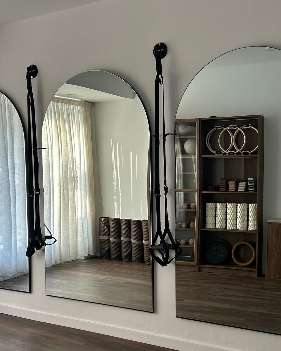 Gimnasio de pilates con espejos en arco y equipamiento de suspensión en Senara Studio